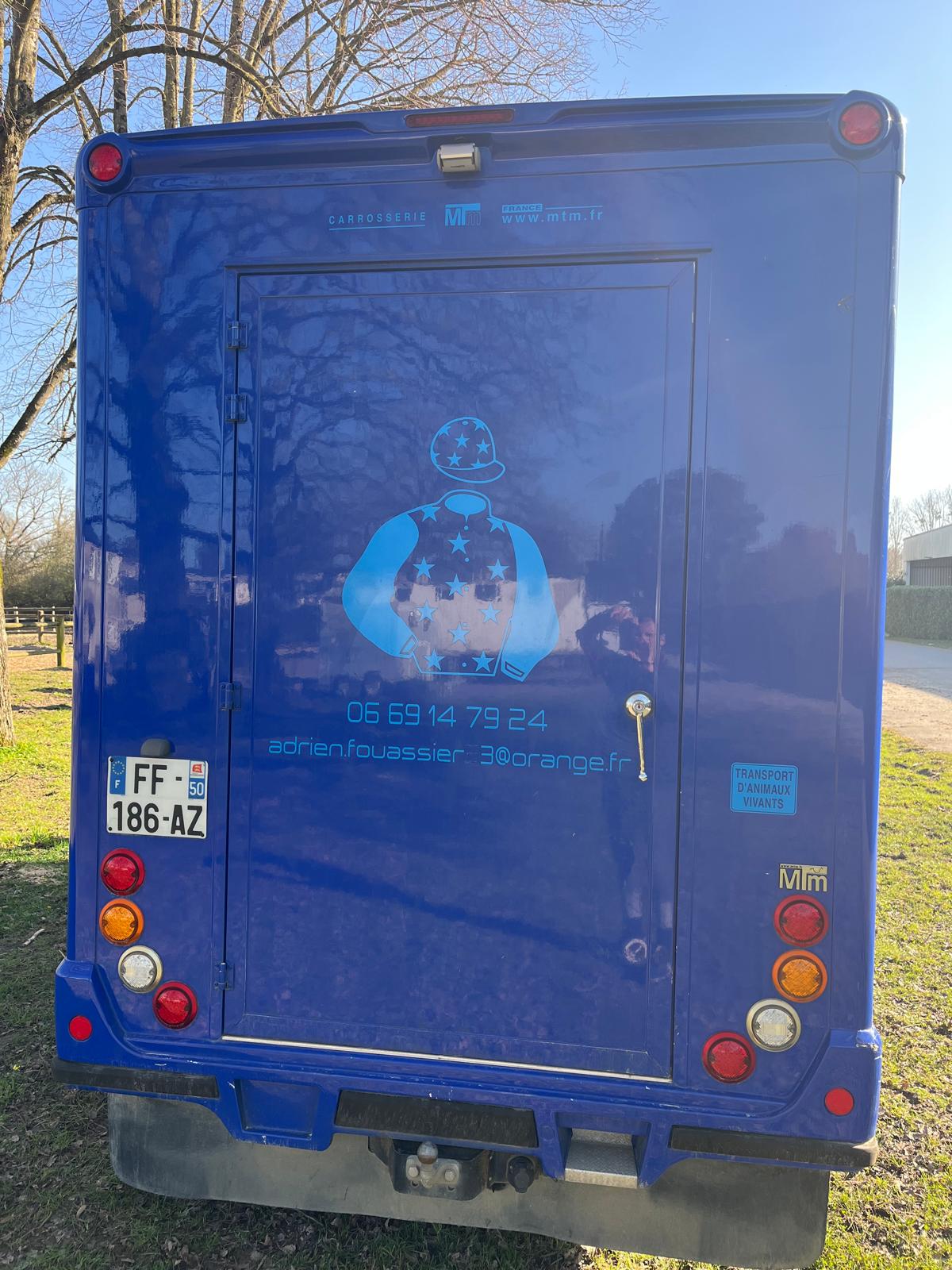 Camion Bleu vu de derrière, texte : Louez-moi!, numéro de téléphone : 06 83 81 73 21, Nom : Adrien Lacombe