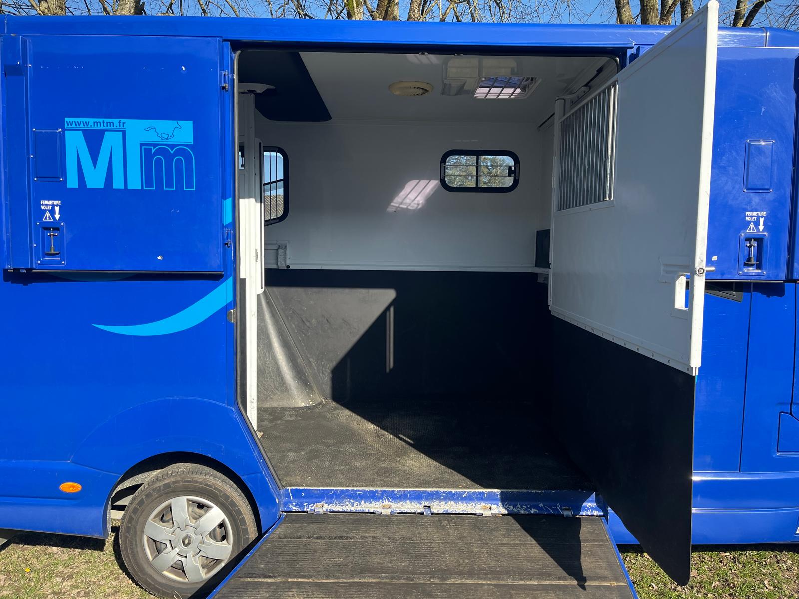Camion Bleu porte ouverte en grand et rampe d'accès pour les chevaux
